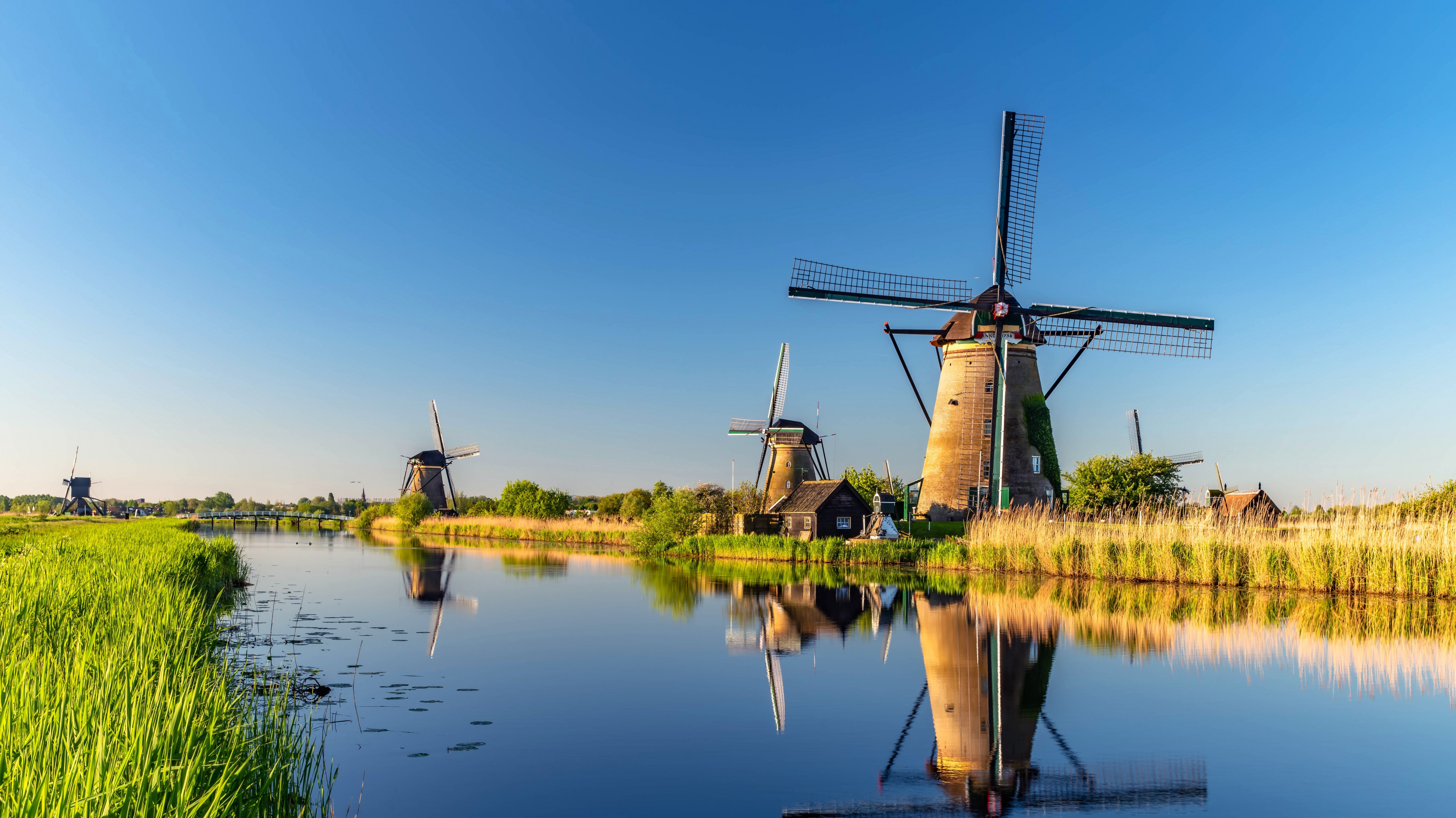 Experience the beauty of the Dutch countryside with this stunning 4K wallpaper of the windmills at Kinderdijk. This picturesque landscape scenery is perfect for nature lovers and those who appreciate the charm of traditional windmills.