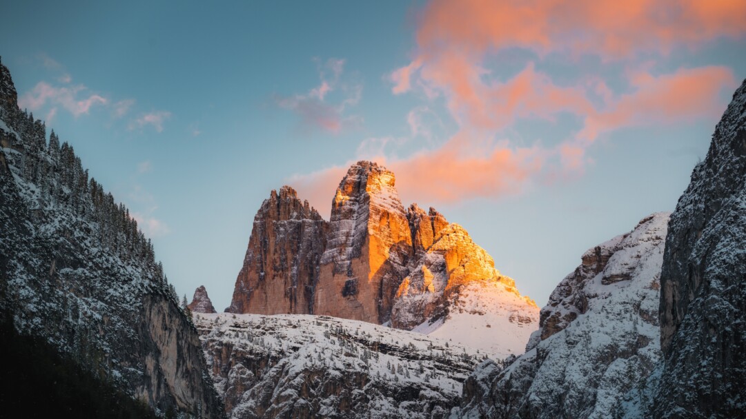 Experience the stunning natural beauty of Italy's Tre Cime di Lavaredo mountain range with this 4K wallpaper. Featuring a breathtaking landscape of rugged peaks and pristine alpine lakes, this outdoor scenery wallpaper is perfect for nature enthusiasts and mountain lovers alike.