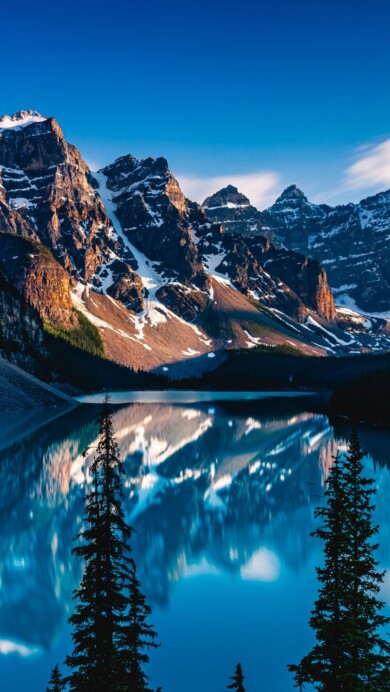 Immerse yourself in the serene beauty of Moraine Lake in Canada with this stunning 4K wallpaper. The turquoise waters, surrounded by the majestic Rocky Mountains in Banff National Park, create a breathtaking scene with perfect mountain reflections. Ideal for travelers and those seeking a desktop background that captures the essence of natural tranquility and scenic wonder.