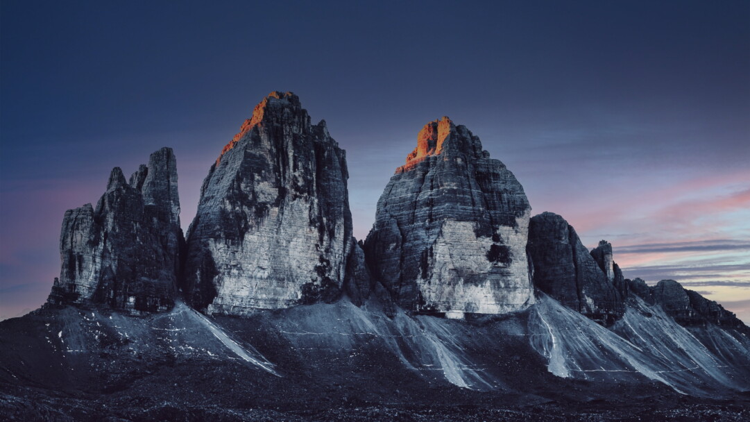 Immerse yourself in the breathtaking beauty of the Three Peaks of Lavaredo in Italy's Dolomites with this captivating 4K wallpaper. These iconic alpine peaks and their rugged landscape create a tranquil and scenic escape. Perfect for travelers and those seeking a desktop background that captures the natural wonder and serenity of these famous mountains.