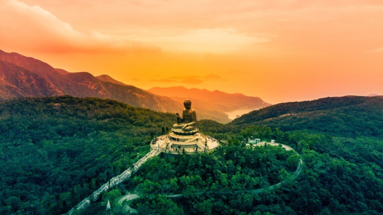 Experience the spiritual serenity of the Tian Tan Buddha statue in Hong Kong with this exquisite 4K wallpaper. This iconic religious landmark on Lantau Island stands as a symbol of Buddhism's cultural heritage. Perfect for those seeking a peaceful and spiritual desktop background, showcasing the statue's serene presence.