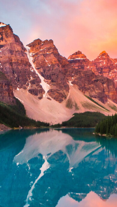 Experience the serene beauty of a captivating sunset at Moraine Lake in Banff National Park, Canada, through this 4K wallpaper. The vibrant hues reflecting on the tranquil waters create a picturesque scene, capturing the essence of this iconic location in high resolution.