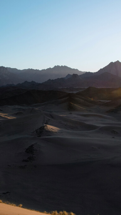 A mesmerizing 4K PC wallpaper captures the vast expanse of Saudi Arabia's sand dunes, stretching endlessly beneath a clear blue sky. The golden hues of the desert landscape create a serene and captivating scene, perfect for adorning your desktop with the beauty of nature's grandeur.